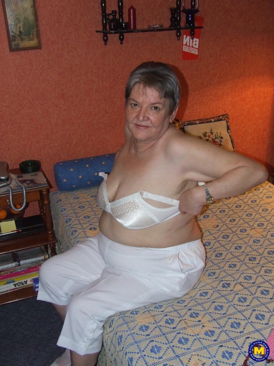 20P Die dicke Oma Uschi zieht ihre Kleider aus, posiert nackt und masturbiert auf einem Bett