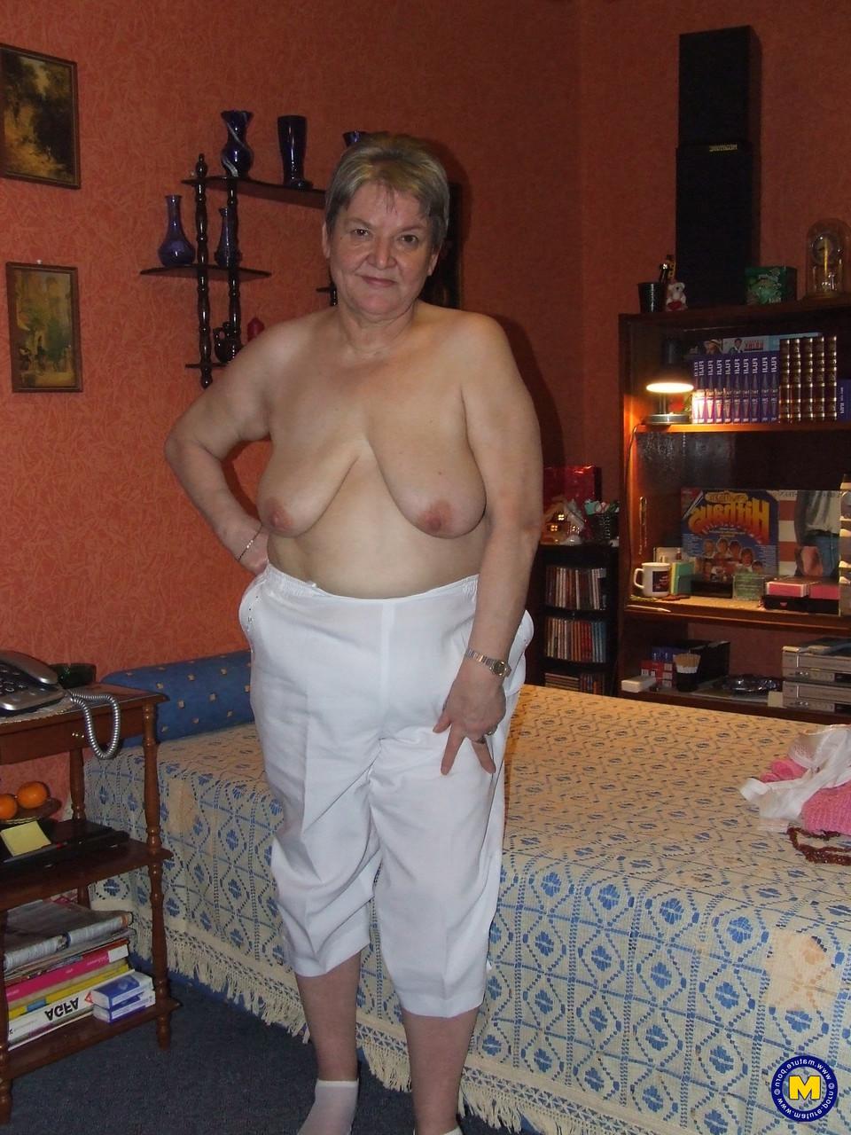 20P Die dicke Oma Uschi zieht ihre Kleider aus, posiert nackt und masturbiert auf einem Bett
