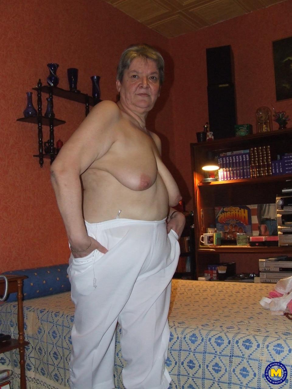 20P Die dicke Oma Uschi zieht ihre Kleider aus, posiert nackt und masturbiert auf einem Bett