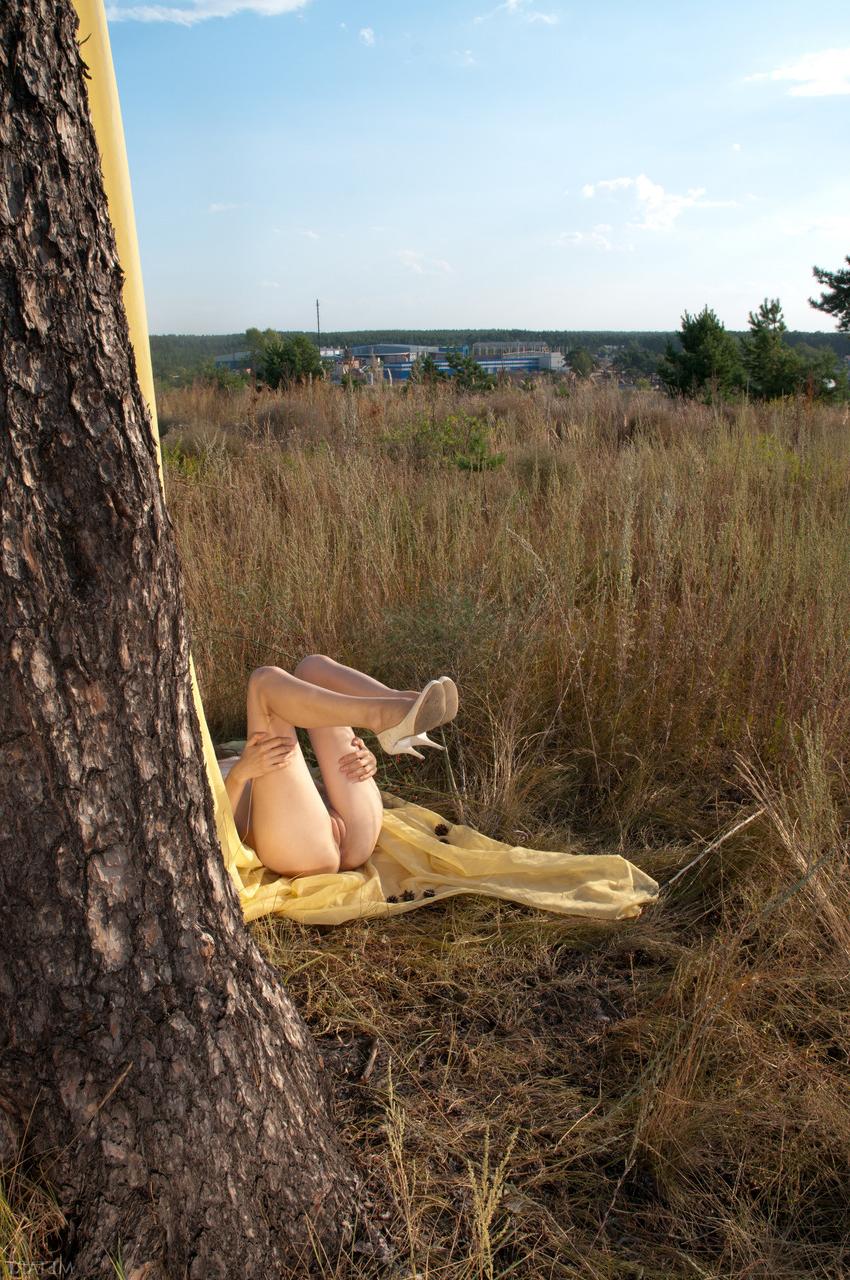 20P La jeune glamour Kitana A se déshabille et pose nue près d'un immense arbre.