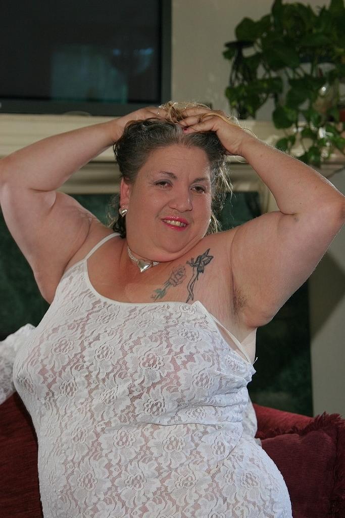 20P La gorda madura Patty Godfrey deja salir sus grandes tetas caídas y posa en solitario