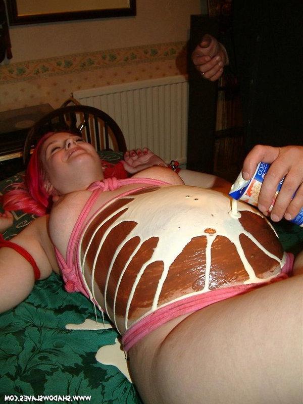 12P La chica embarazada tiene su barriga decorada con comida en una mesa
