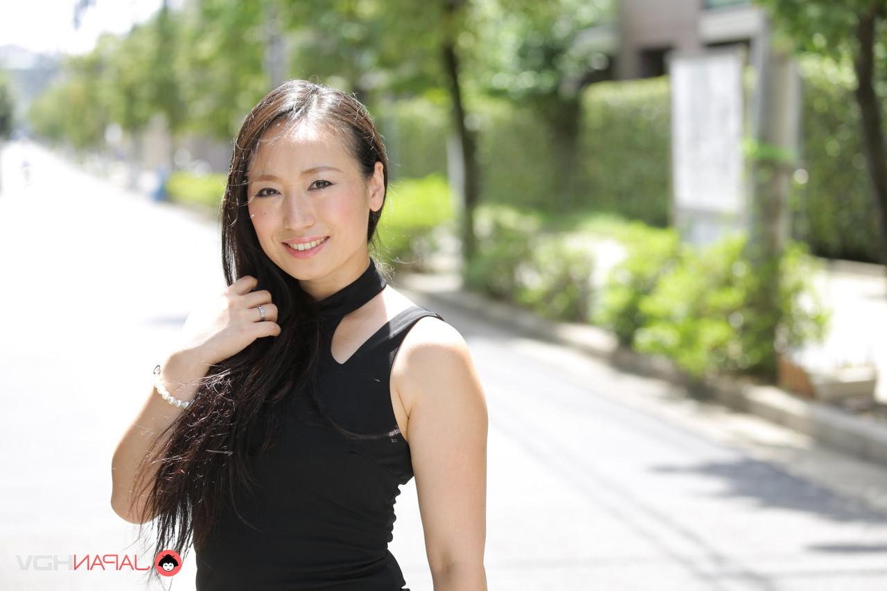 15P La beauté japonaise Aya Shiina est mannequin dans une rue de la ville dans une robe noire.