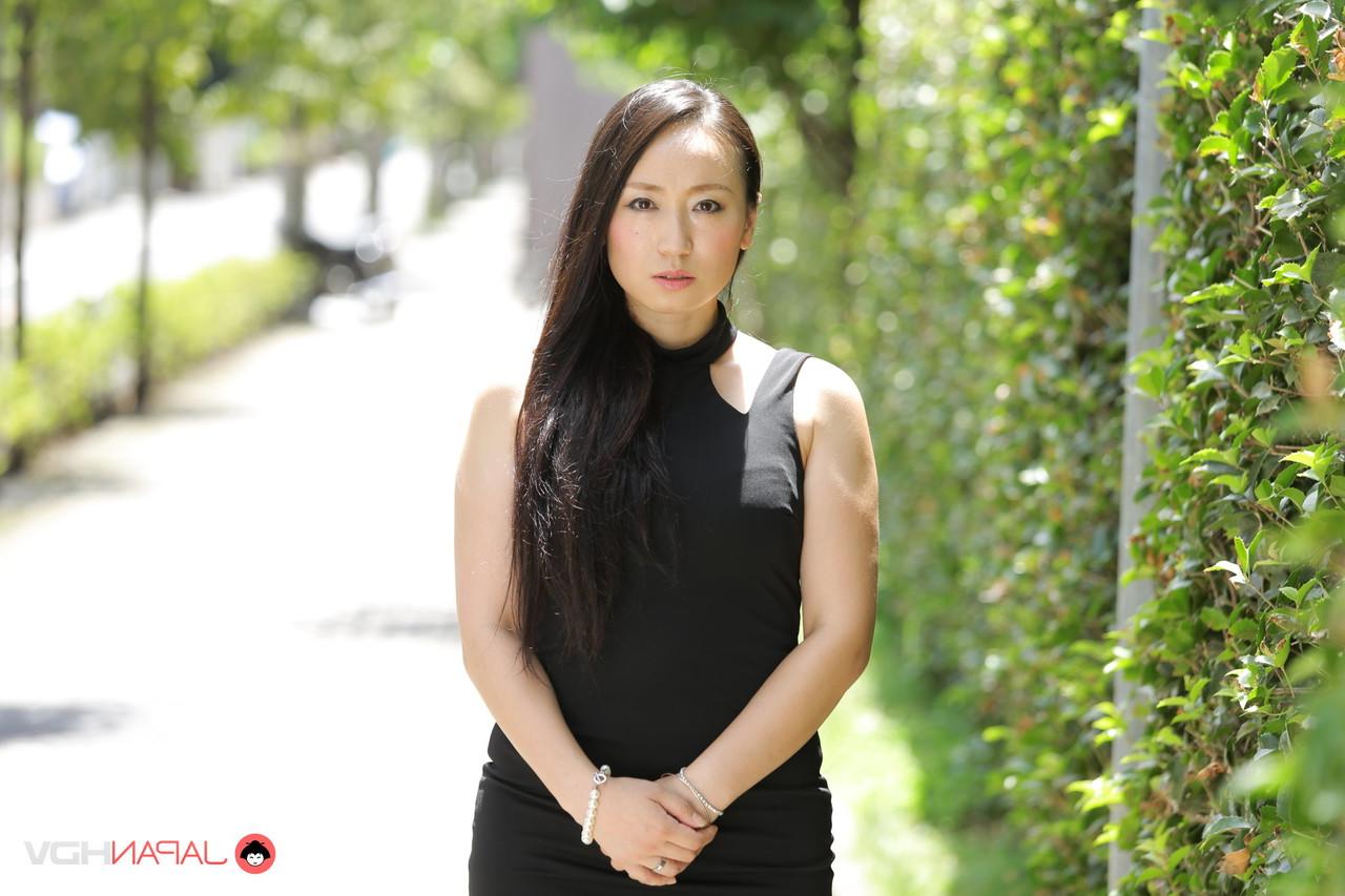 15P La beauté japonaise Aya Shiina est mannequin dans une rue de la ville dans une robe noire.