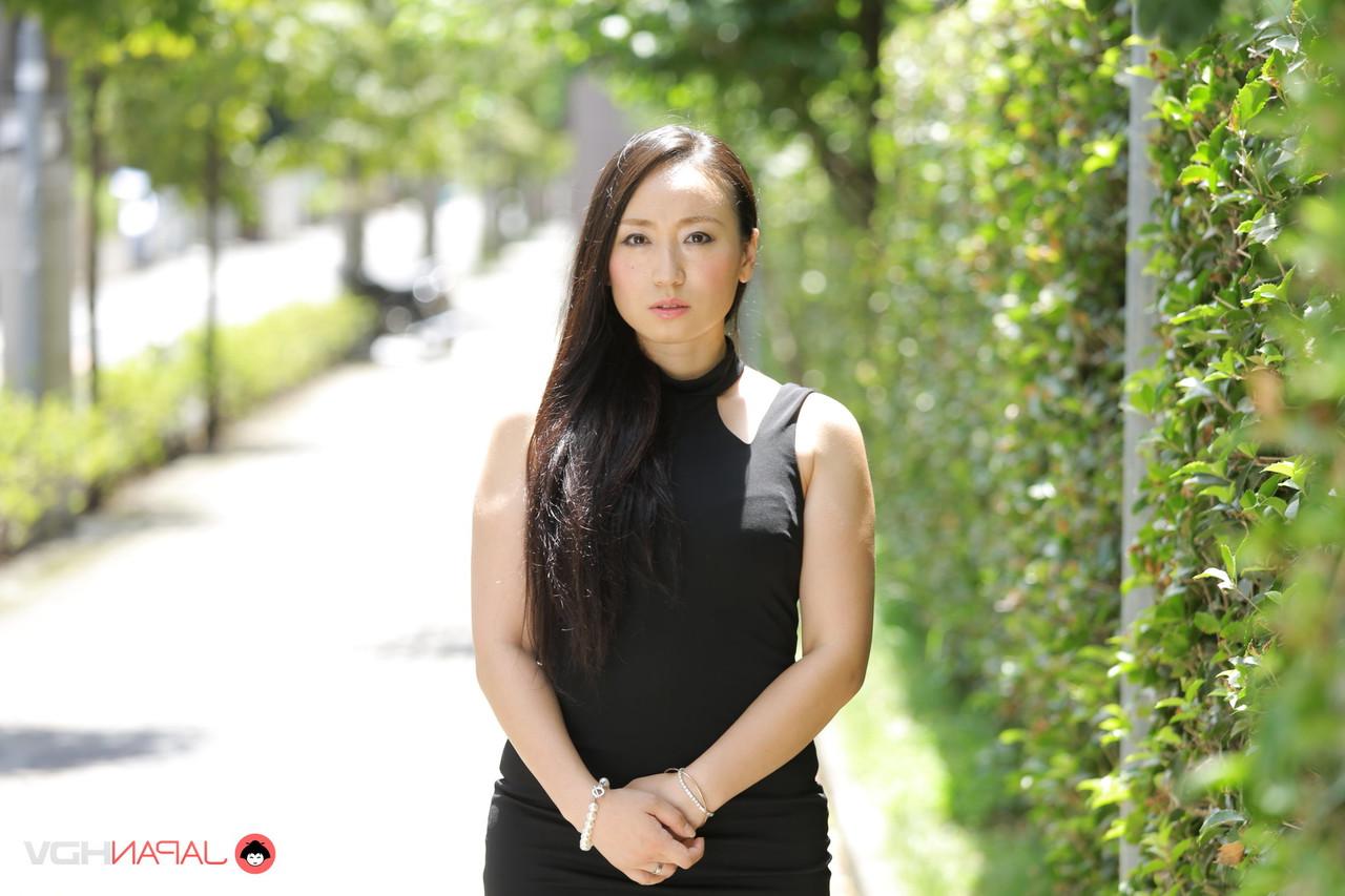 15P La beauté japonaise Aya Shiina est mannequin dans une rue de la ville dans une robe noire.