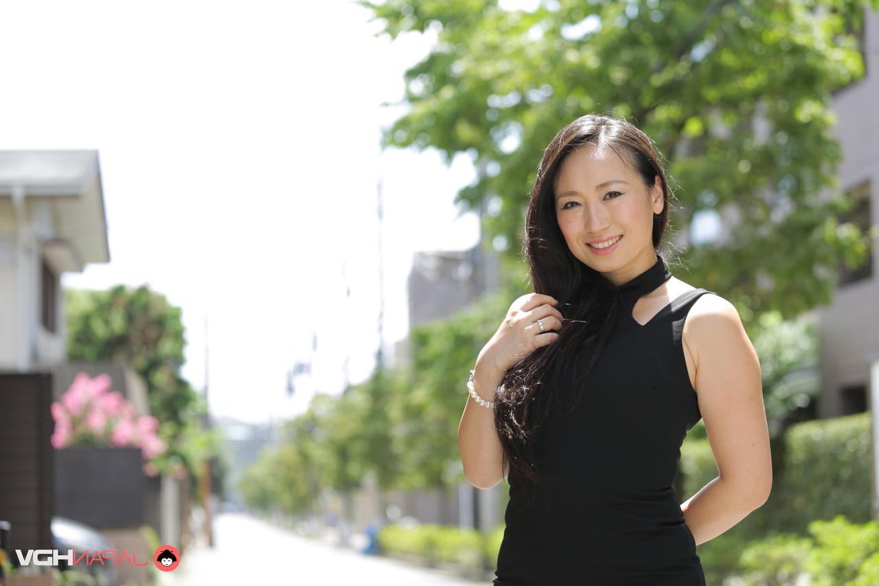 15P La beauté japonaise Aya Shiina est mannequin dans une rue de la ville dans une robe noire.