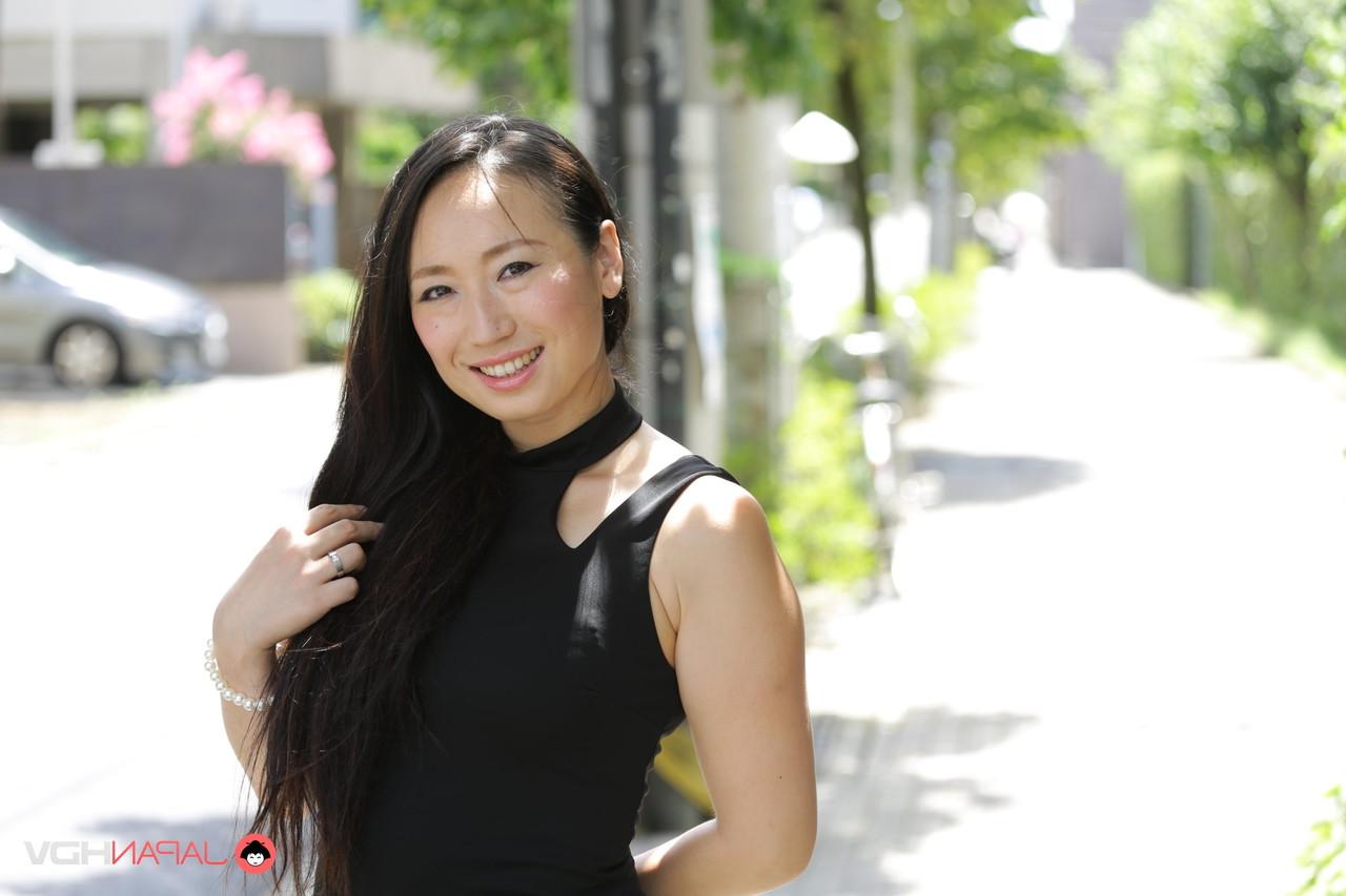 15P La beauté japonaise Aya Shiina est mannequin dans une rue de la ville dans une robe noire.
