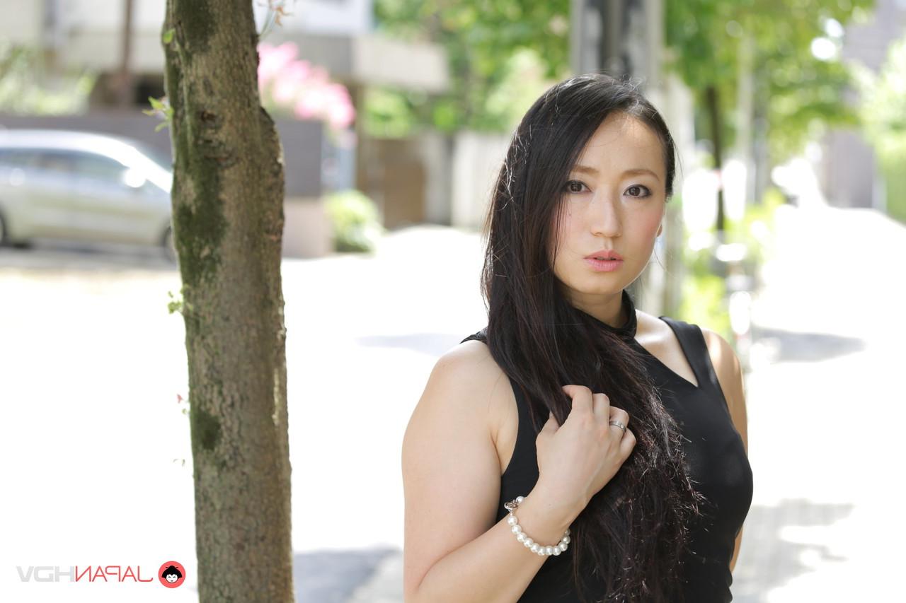 15P La beauté japonaise Aya Shiina est mannequin dans une rue de la ville dans une robe noire.