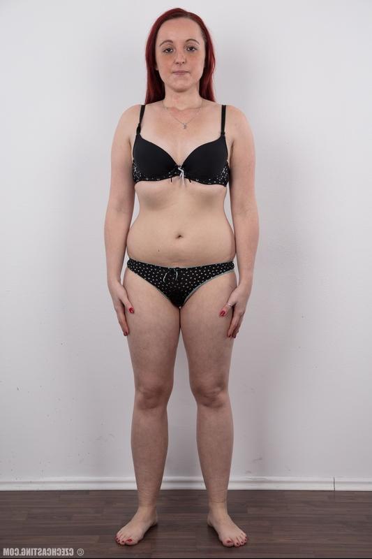 20P Katerina, une amatrice rousse et potelée, se tient nue après avoir enlevé ses vêtements.