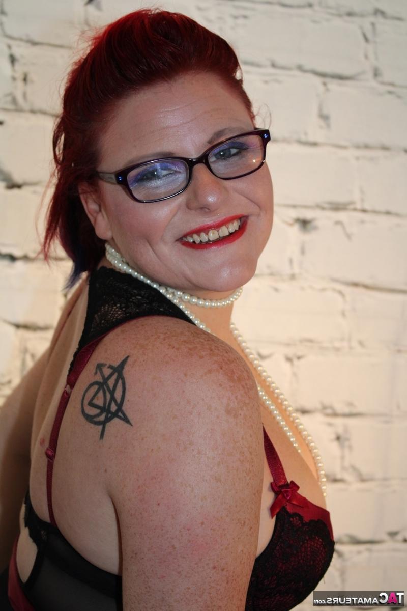 16P Chubby redhead looses her tits from lingerie while wearing glasses and nylons