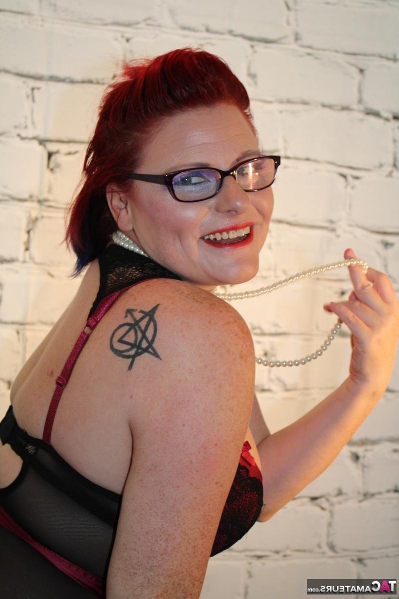 16P Chubby redhead looses her tits from lingerie while wearing glasses and nylons