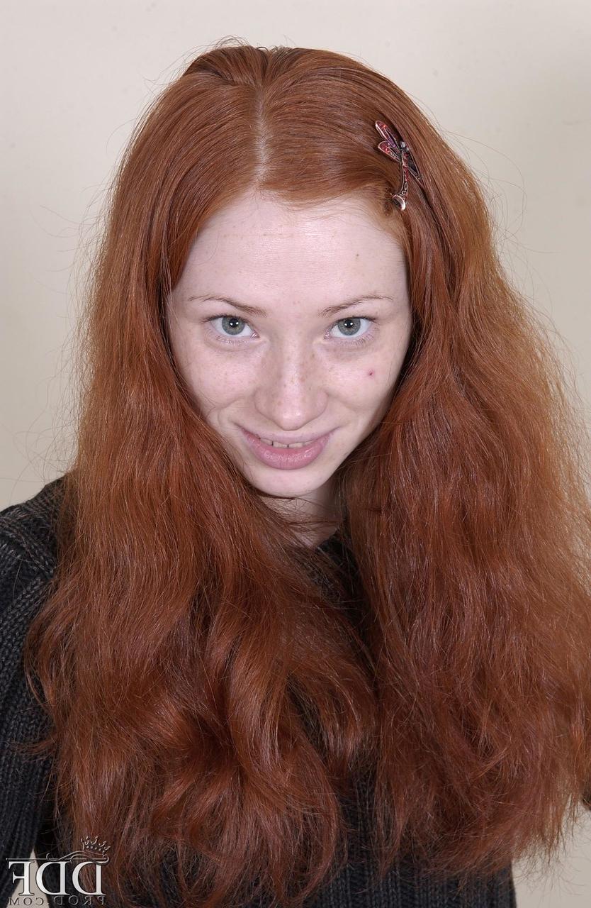 20P Redheaded American babe Millena exposes her slim body and presents her cunt