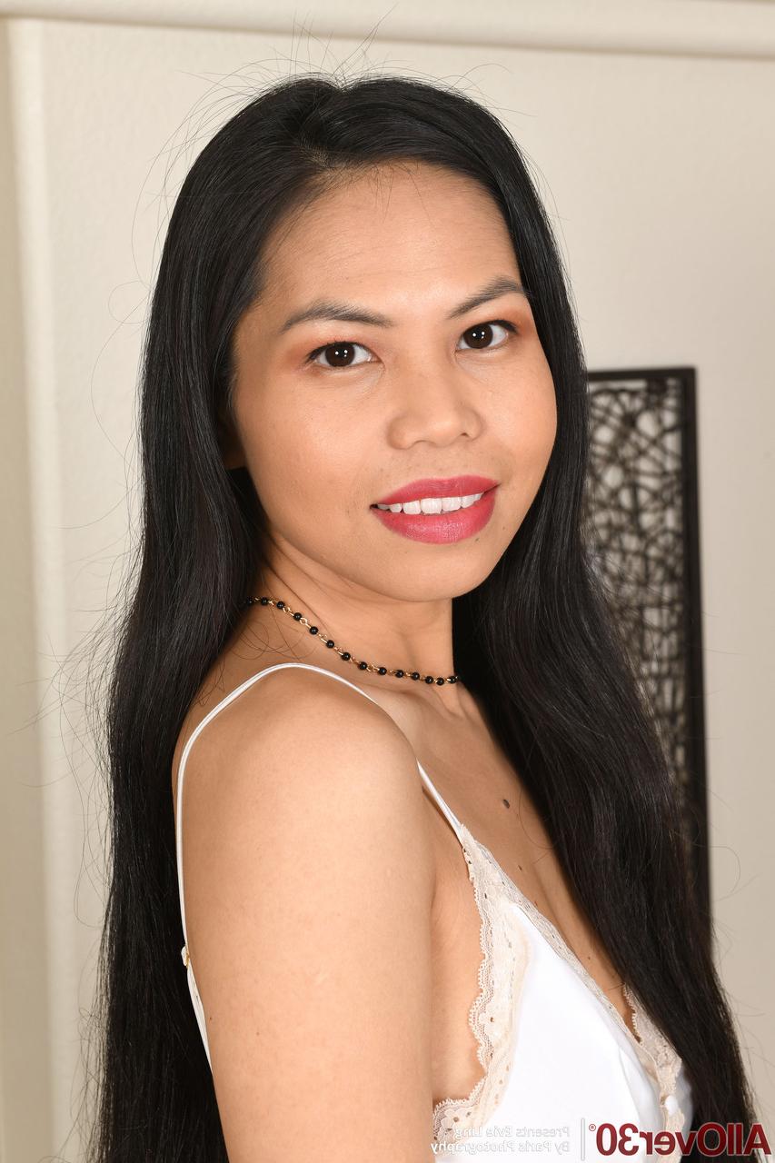20P La belle asiatique Evie Ling se déshabille et écarte sa chatte rasée.