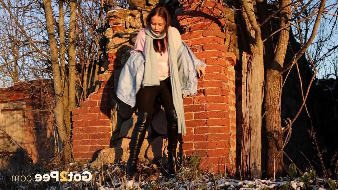 15P Pinkycat, une asiatique, s'accroupit pour pisser sur un sol gelé près d'un mur de briques.