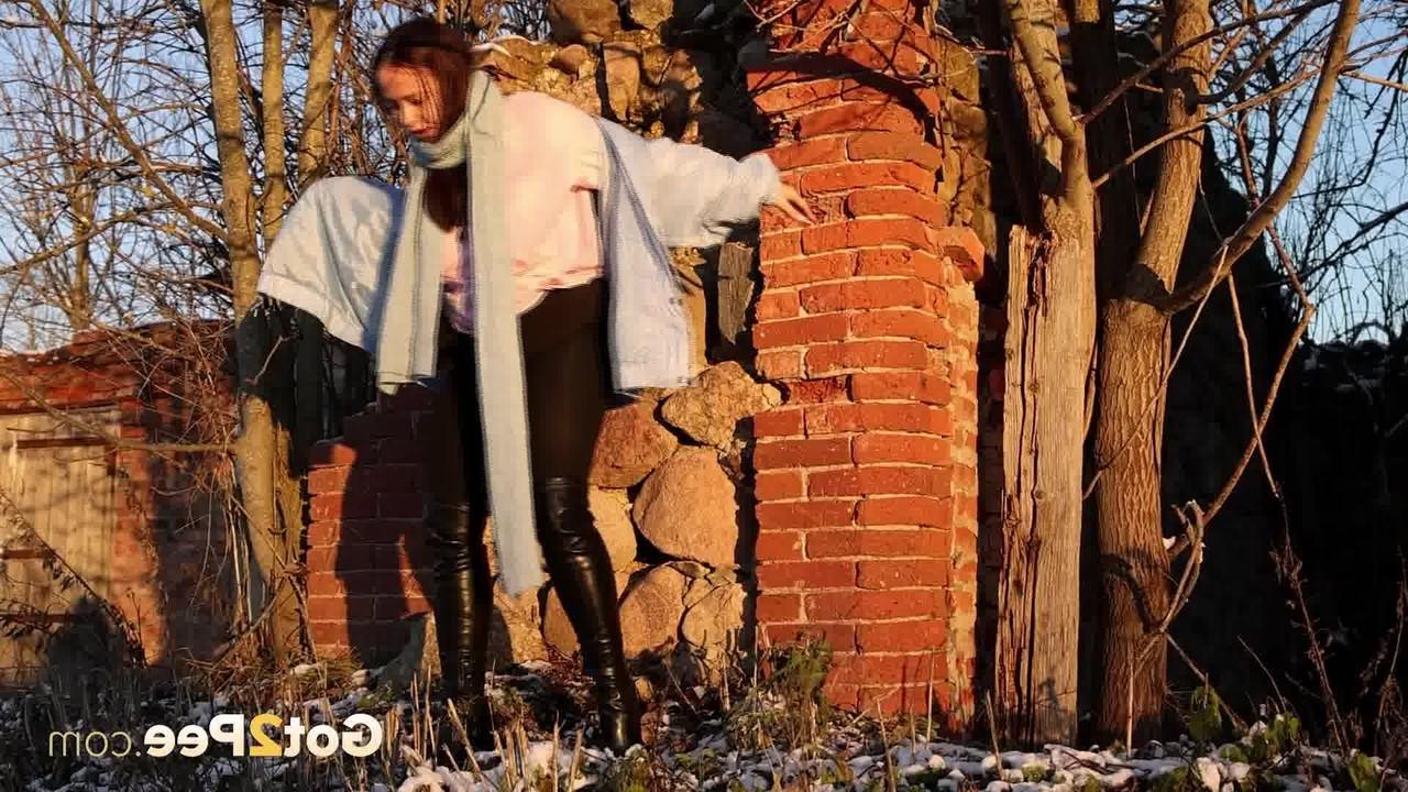 15P Pinkycat, une asiatique, s'accroupit pour pisser sur un sol gelé près d'un mur de briques.