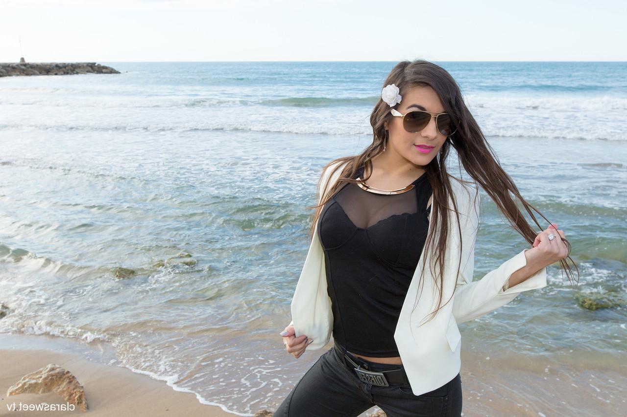 15P A modelo totalmente natural Clara Sweet posando na praia com sua roupa sexy e salto alto