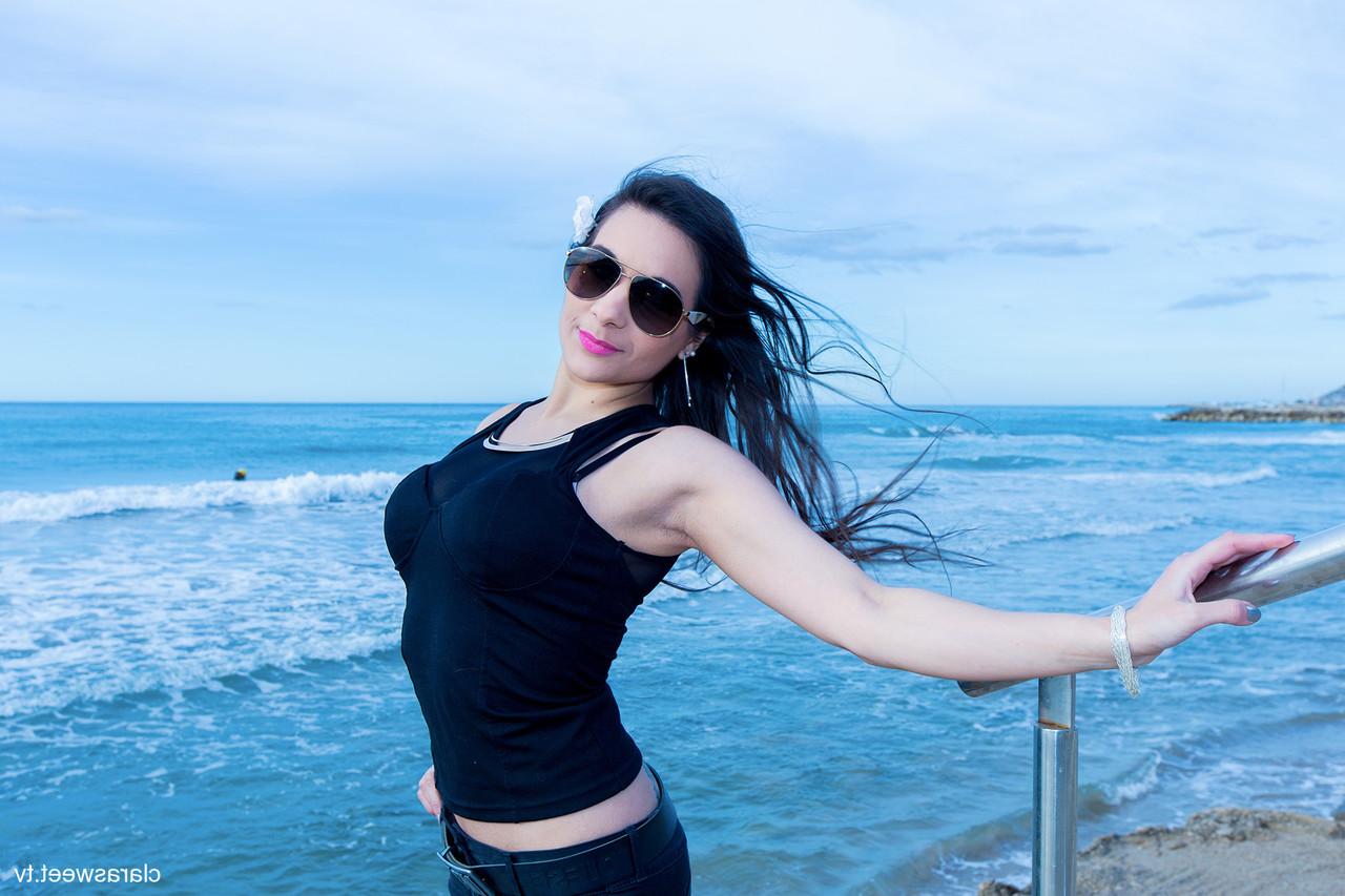15P A modelo totalmente natural Clara Sweet posando na praia com sua roupa sexy e salto alto