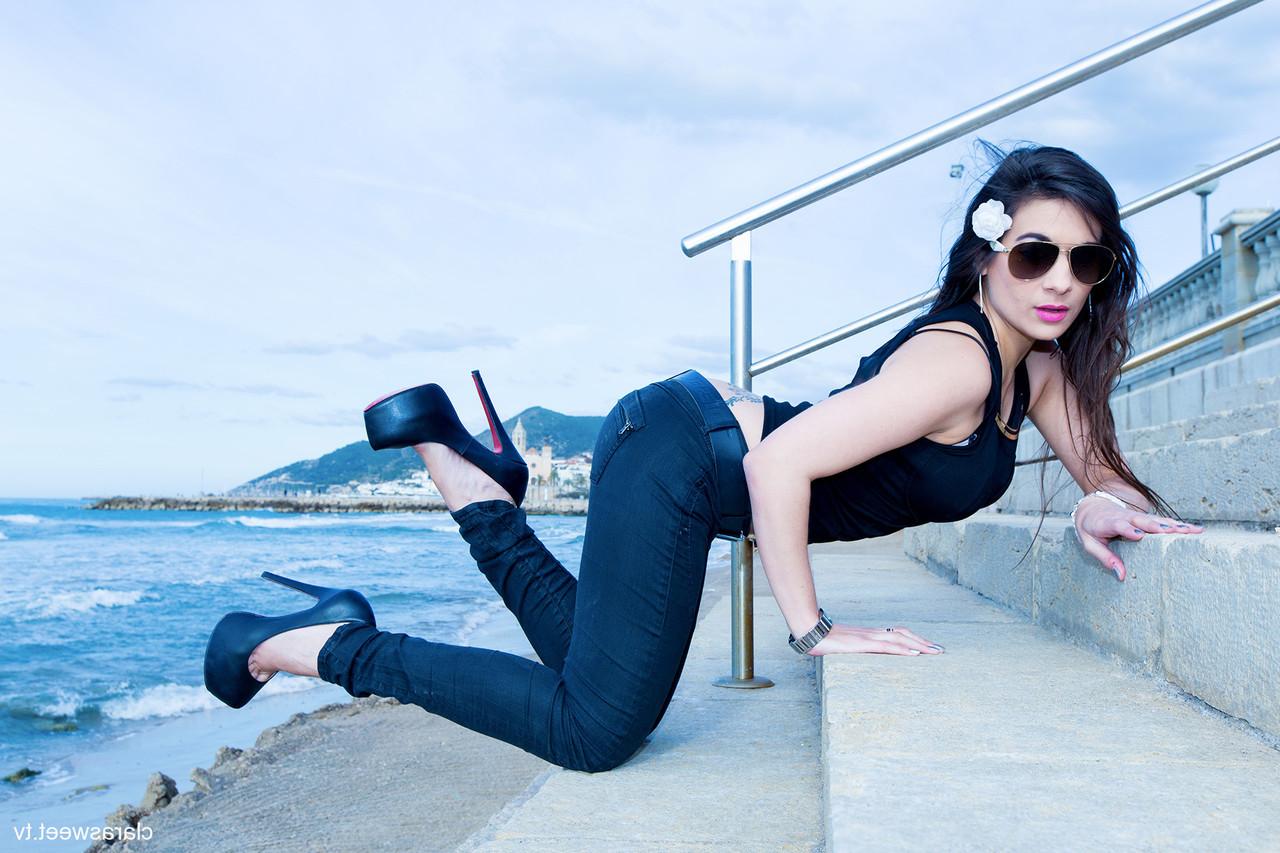 15P A modelo totalmente natural Clara Sweet posando na praia com sua roupa sexy e salto alto