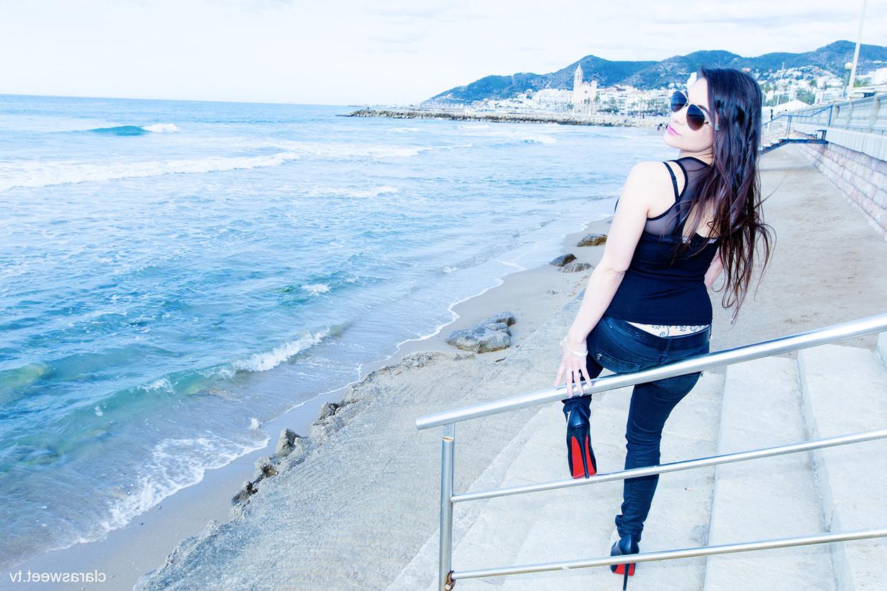 15P A modelo totalmente natural Clara Sweet posando na praia com sua roupa sexy e salto alto