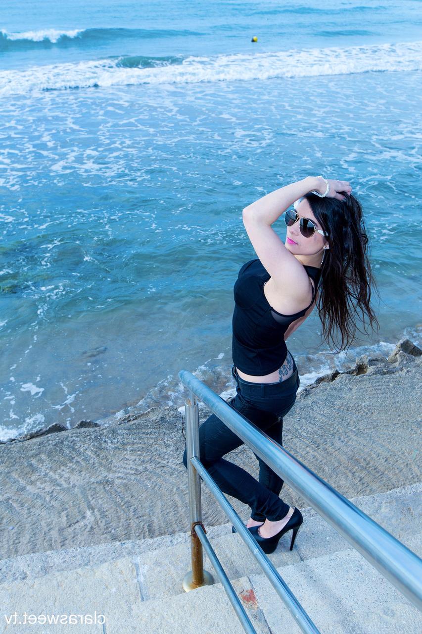 15P A modelo totalmente natural Clara Sweet posando na praia com sua roupa sexy e salto alto