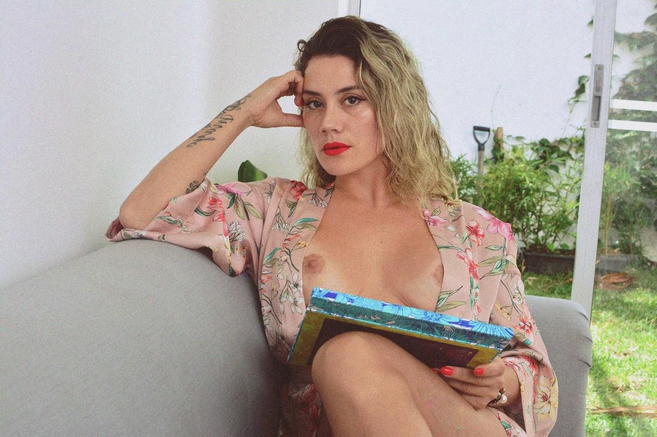 15P La MILF encrée Andrea Garcia expose ses incroyables gros seins en lisant sur un canapé.