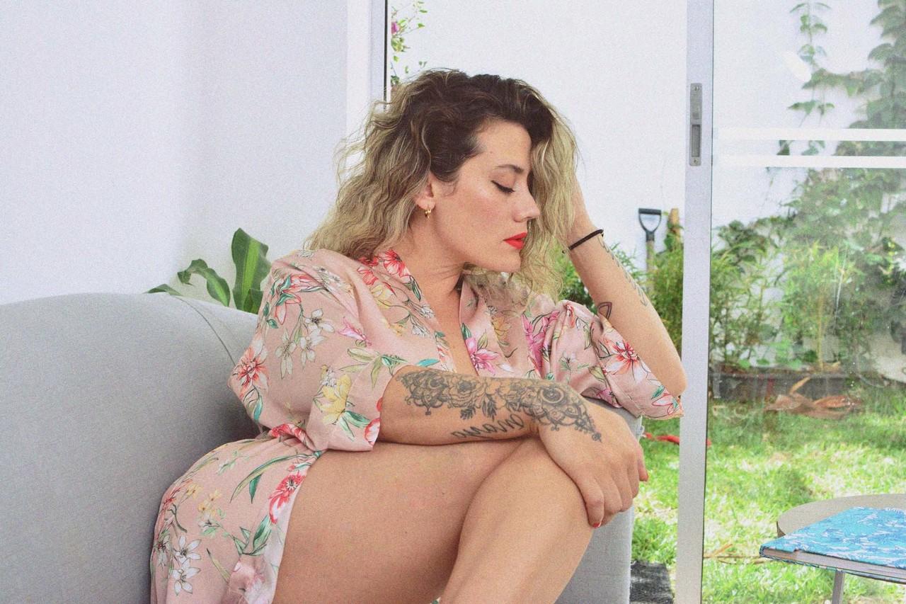 15P La MILF encrée Andrea Garcia expose ses incroyables gros seins en lisant sur un canapé.