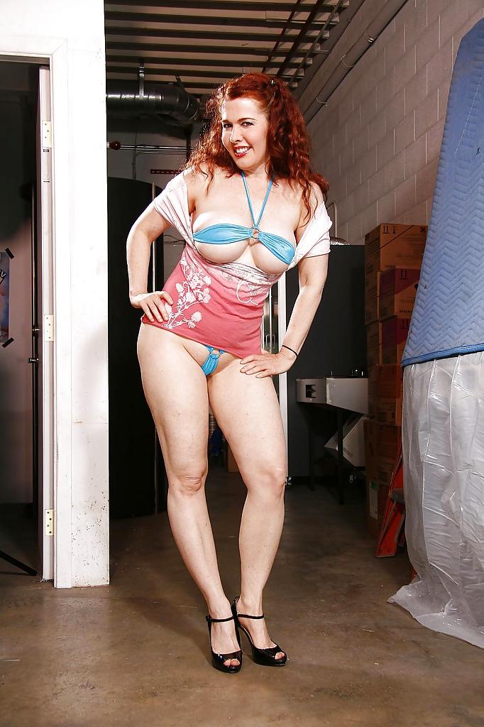 13P Fatty redhead mature lady on high heels revealing her massive jugs