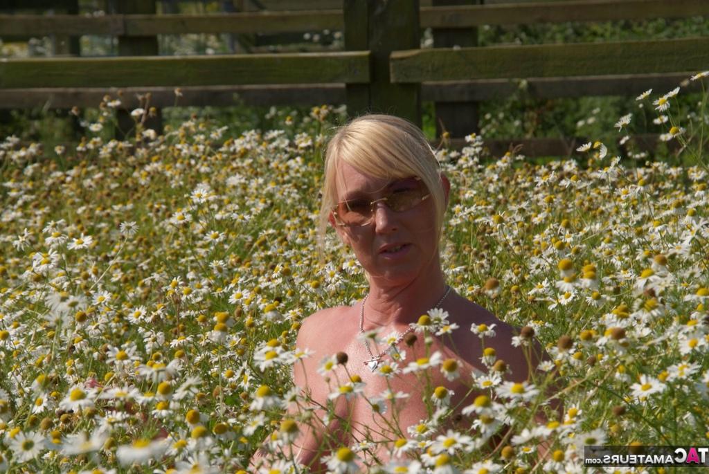 19P Die übergewichtige Blondine Melody entblößt ihre großen Brüste in einem Feld voller wilder Blumen