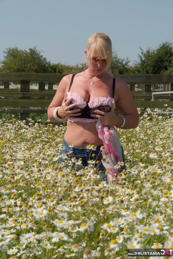 19P Die übergewichtige Blondine Melody entblößt ihre großen Brüste in einem Feld voller wilder Blumen