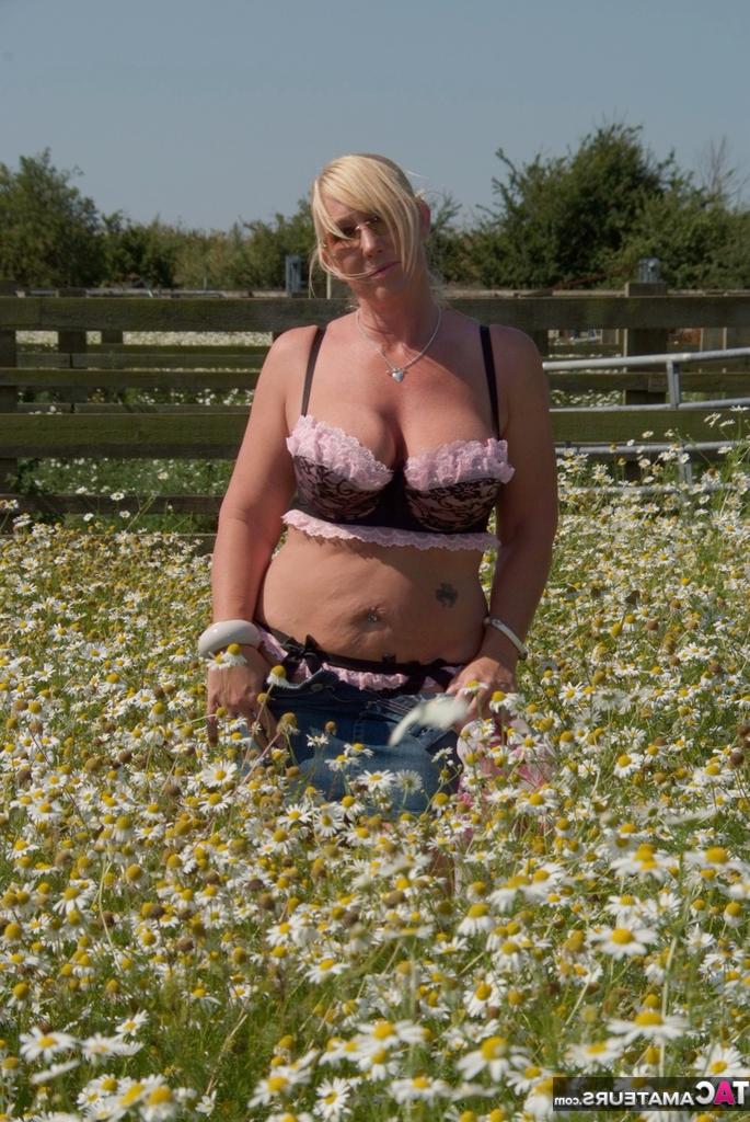 19P Die übergewichtige Blondine Melody entblößt ihre großen Brüste in einem Feld voller wilder Blumen