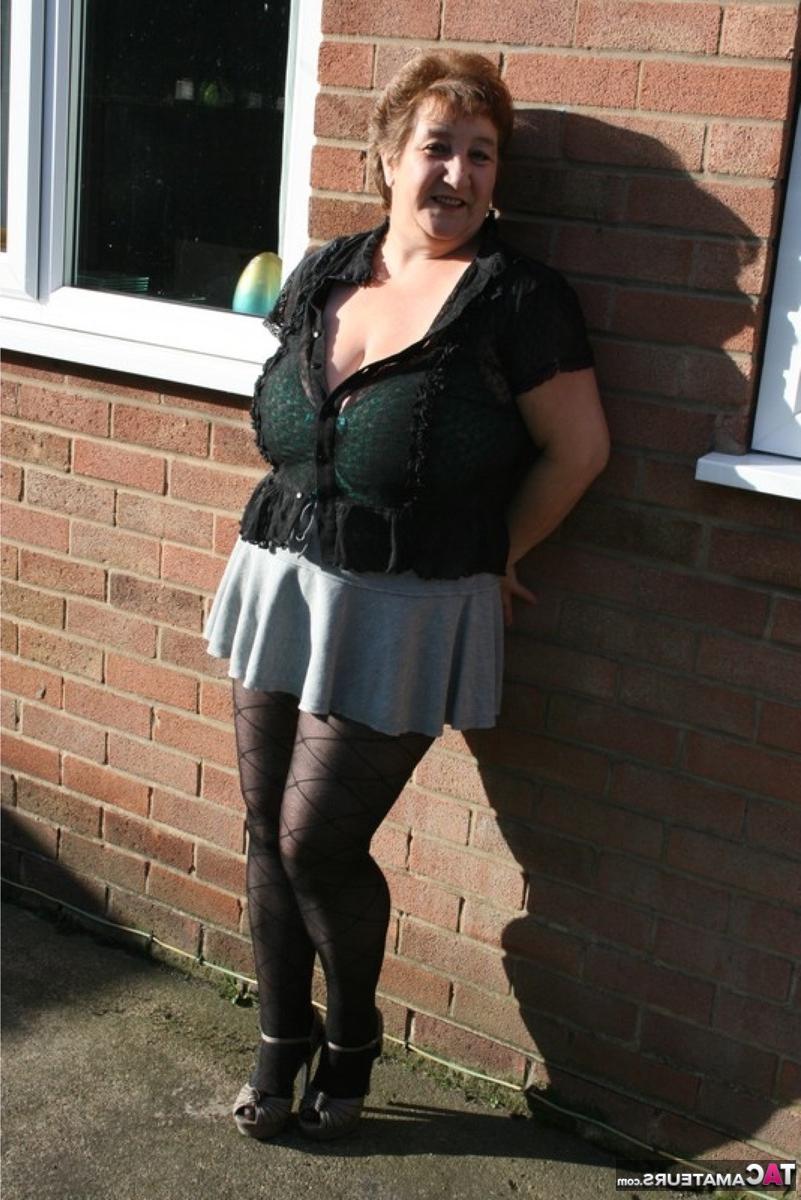 16P Die ältere britische fette Kinky Carol zieht sich vor ihrem Haus bis auf Dessous und Strumpfhosen aus