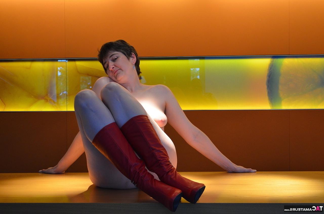 16P Hotmilf, une femme mûre, se déshabille en portant une paire de bottes rouges.