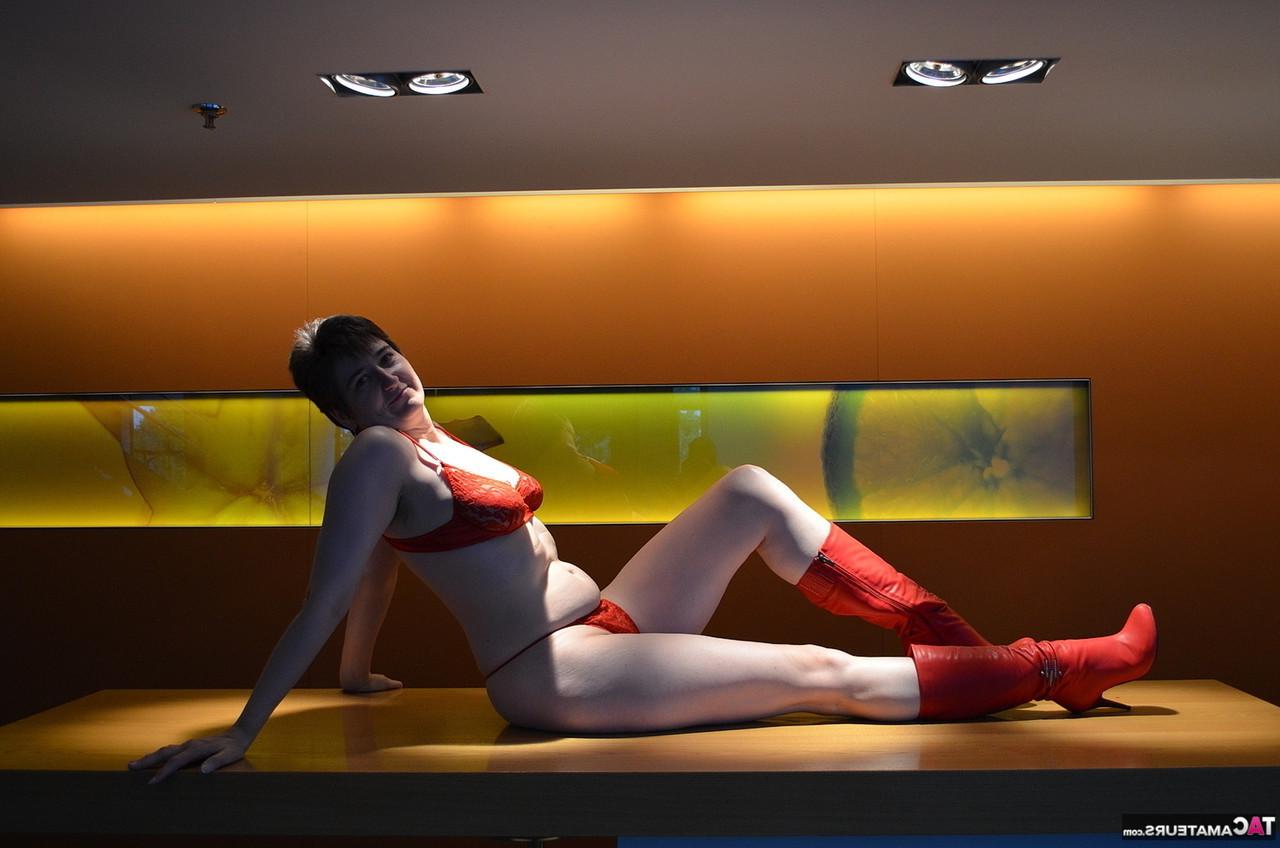 16P Hotmilf, une femme mûre, se déshabille en portant une paire de bottes rouges.