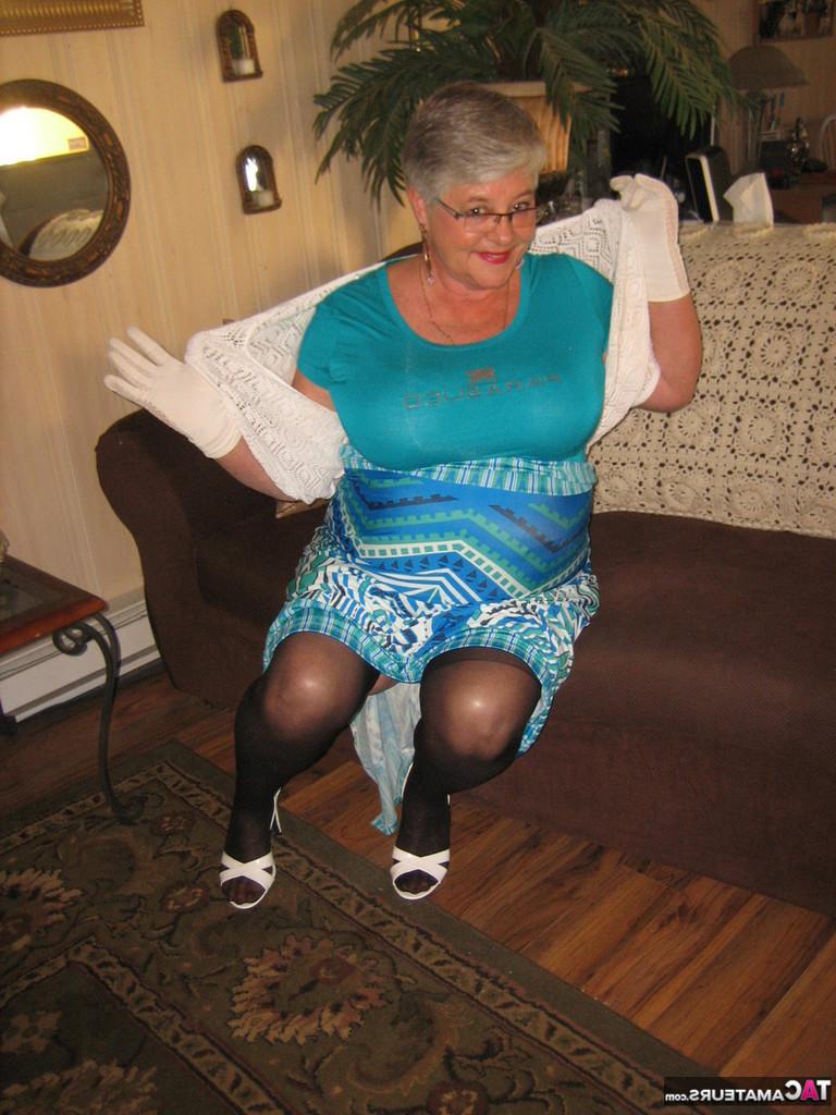 20P Die fette Oma-Gürtelgöttin trägt weiße Handschuhe, während sie sich bis auf einen BH und einen Mieder auszieht