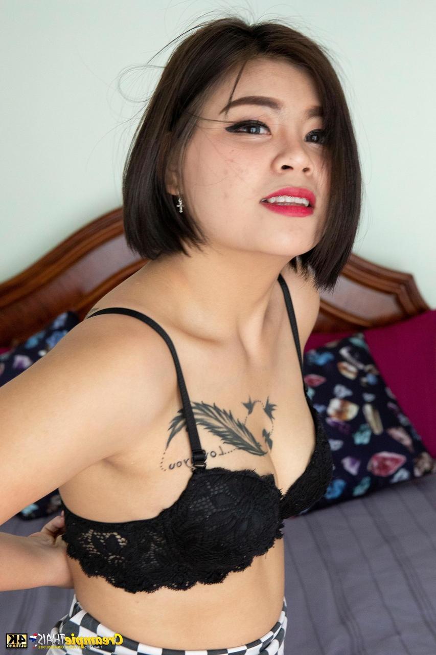20P Laddawan, une jolie jeune thaïlandaise, se déshabille et montre son corps tatoué et son gros butin.