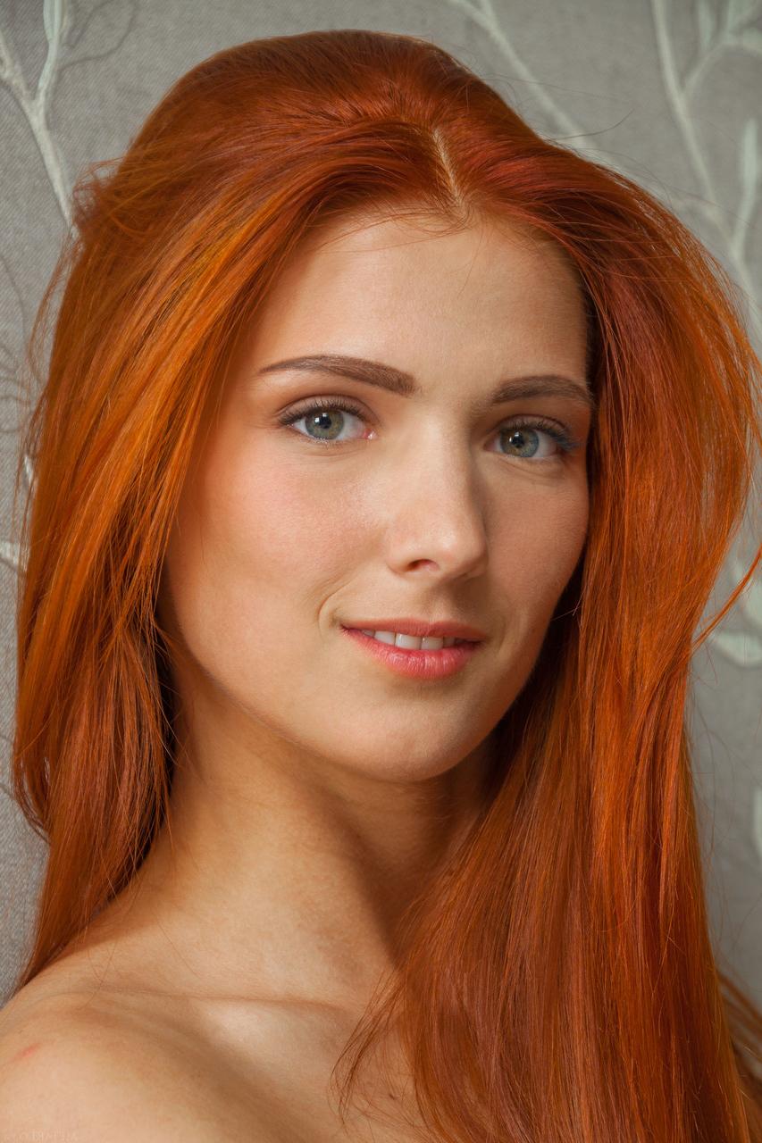 20P Carinela, rousse et sexy, nue, montre ses petits seins et sa chatte rasée.