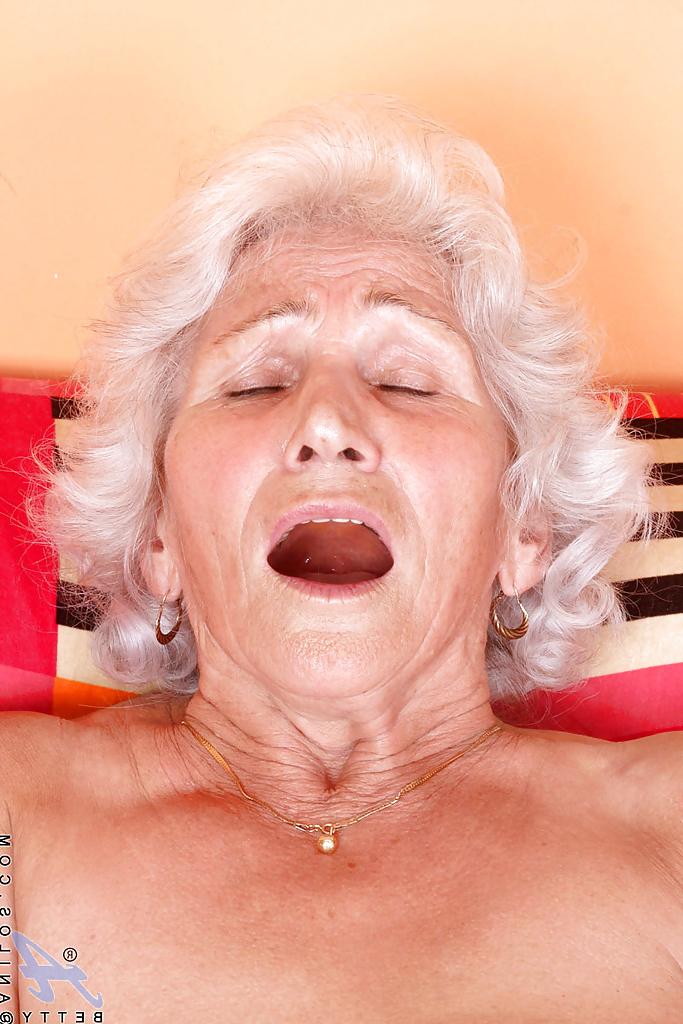 16P Mamie blonde en bas blancs brillants dénude ses seins et se masturbe