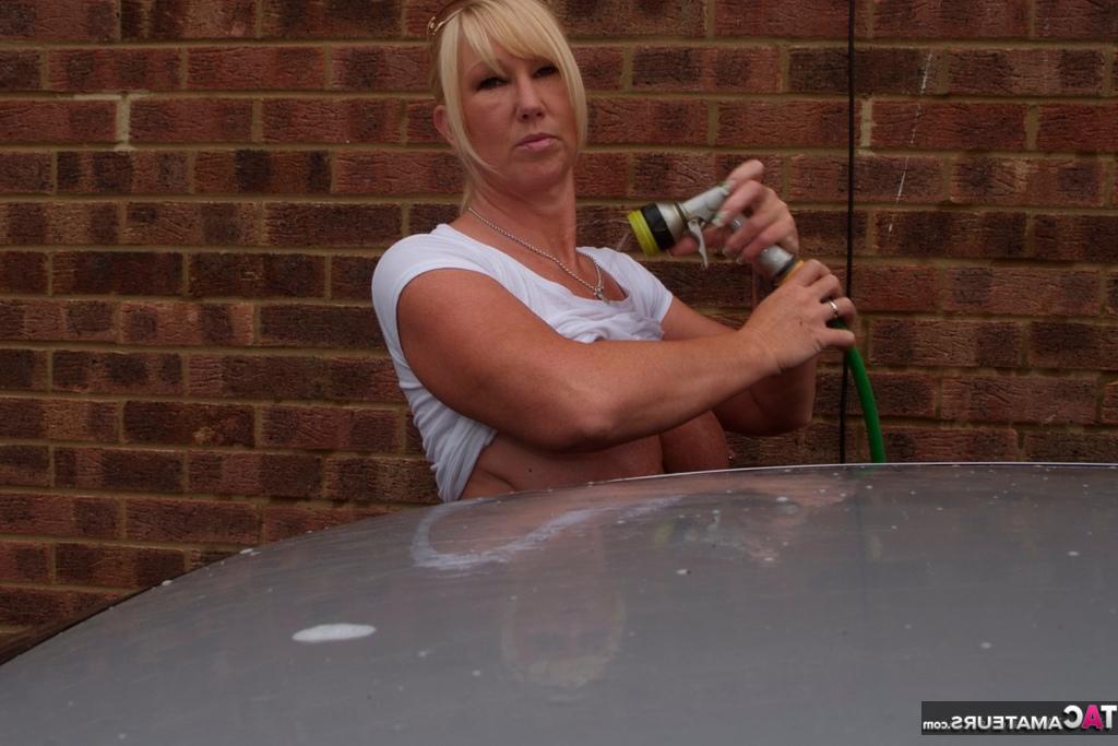 20P Melody, une amatrice blonde aux gros seins, trempe un t-shirt blanc pendant qu'elle lave sa voiture.