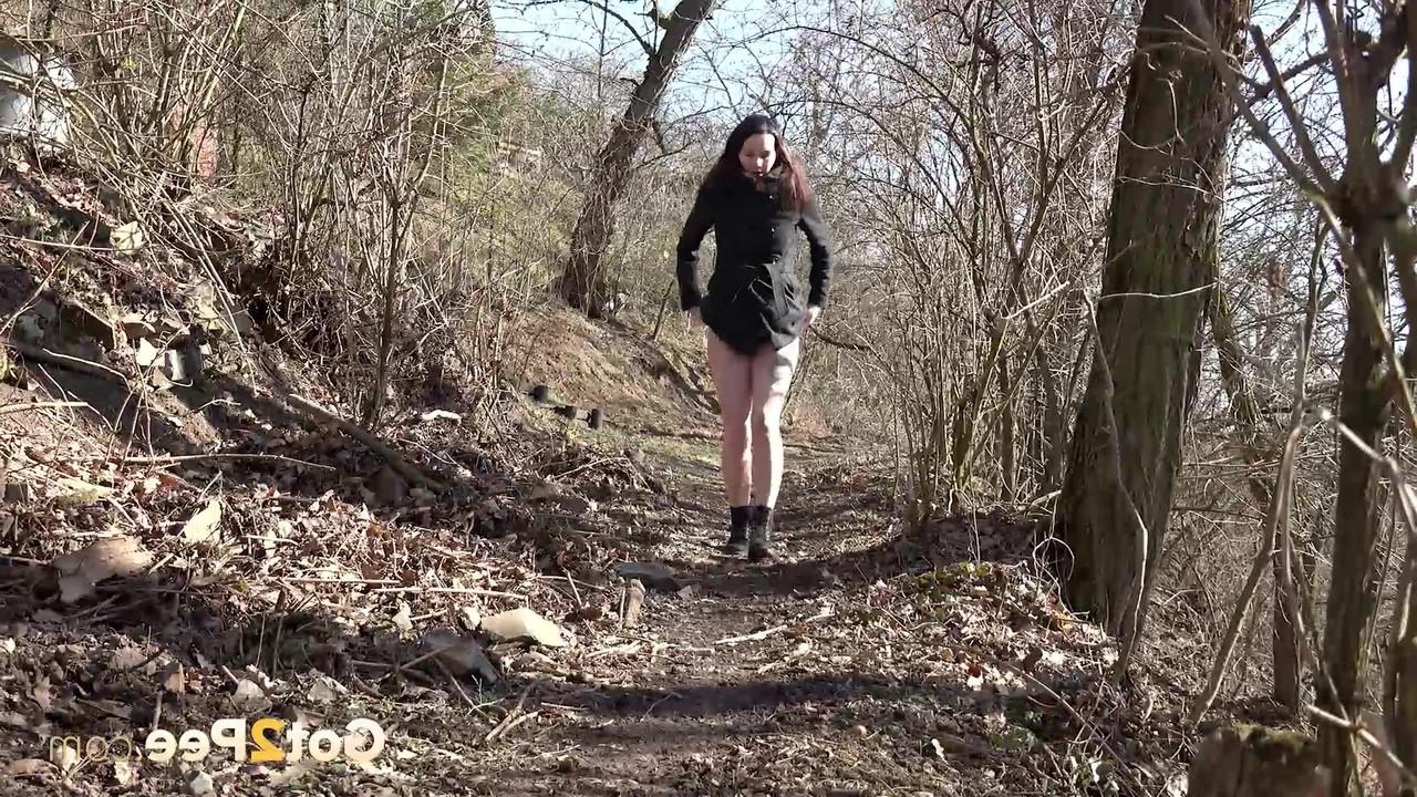 15P Das kaukasische Mädchen Amanda Hill pinkelt auf einem Pfad durch den Wald auf getrocknete Blätter