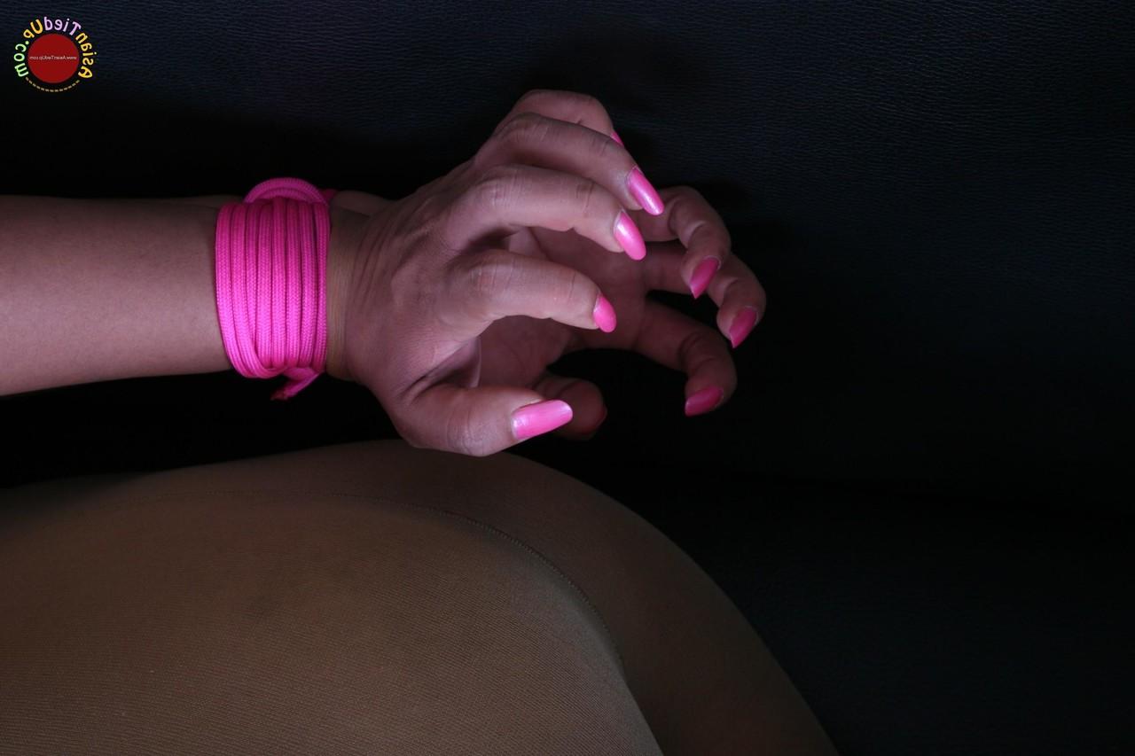 16P Une jolie esclave asiatique fait du sport un peu dans sa bouche alors qu'elle est attachée avec une corde rose.