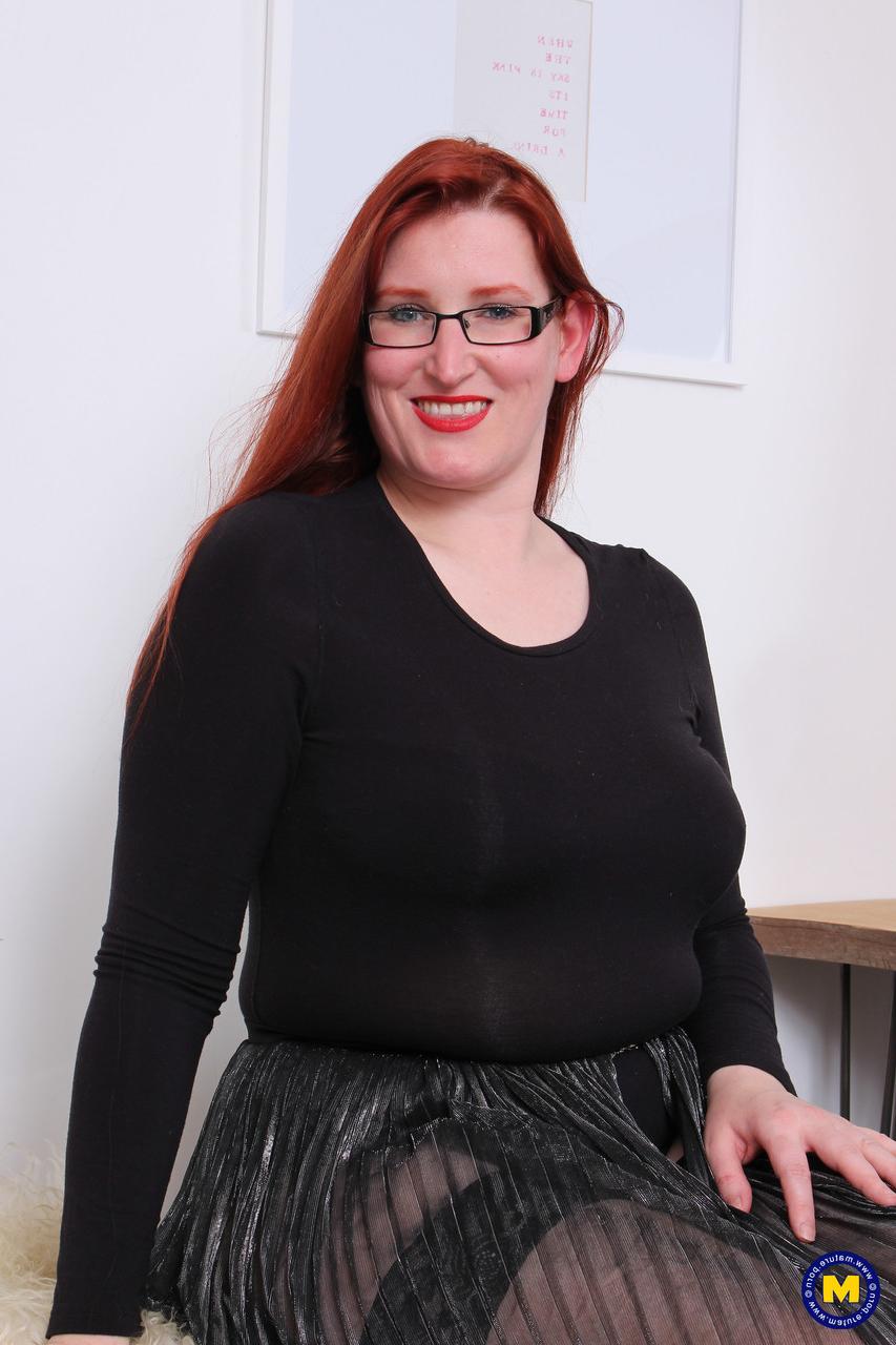 16P Older redhead on the plump side bares her saggy tits before toying her beaver