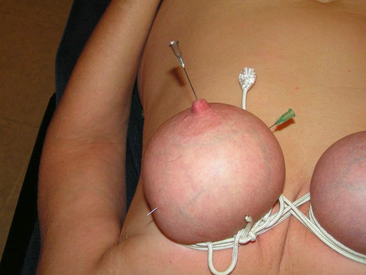 16P Mujer rubia tiene los pechos y los pezones perforados con agujas