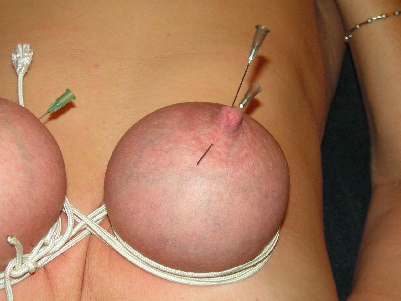 16P Mujer rubia tiene los pechos y los pezones perforados con agujas