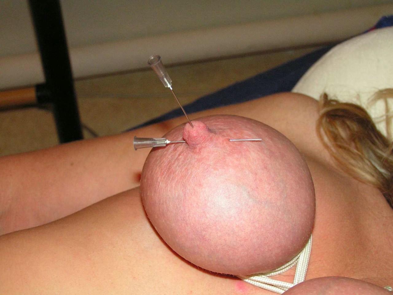 16P Mujer rubia tiene los pechos y los pezones perforados con agujas