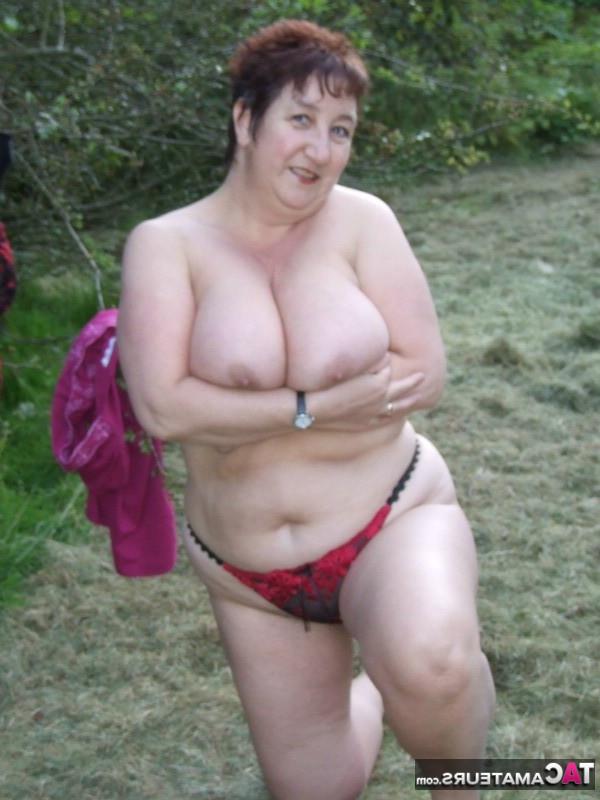 20P La zorra madura de pelo corto Kinky Carol desnudándose y traviesamente en el bosque