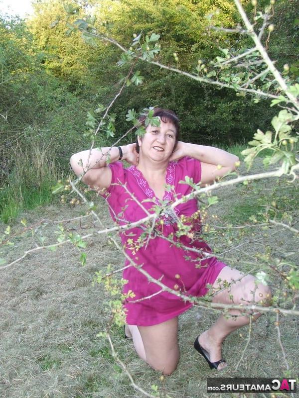 20P La zorra madura de pelo corto Kinky Carol desnudándose y traviesamente en el bosque