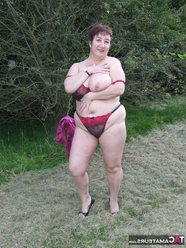 20P La zorra madura de pelo corto Kinky Carol desnudándose y traviesamente en el bosque