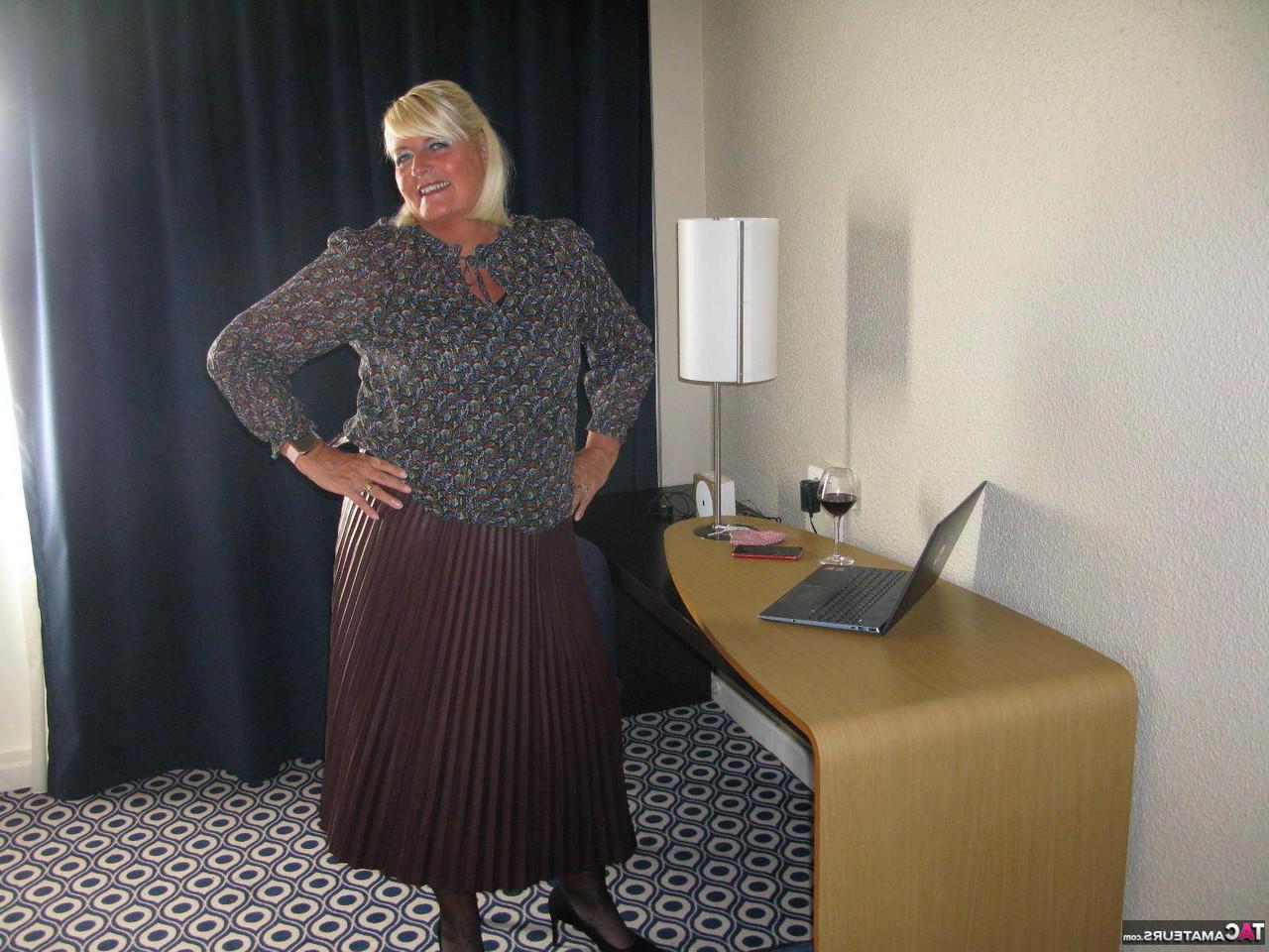 20P Maduro BBW Chrissy Uk mostra os seios e a vulva em uma mesa com uma taça de vinho