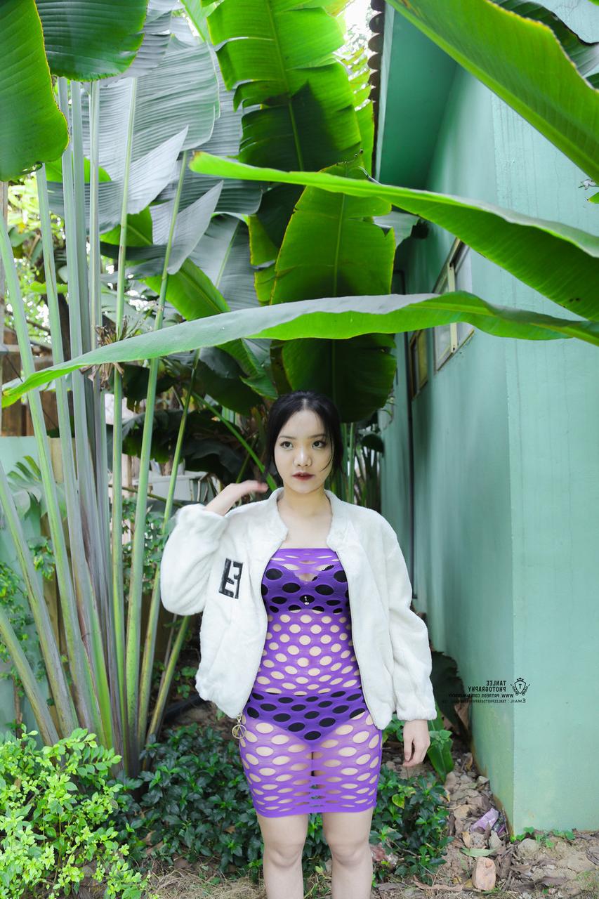 20P Brünettes asiatisches Mädchen posiert in sexy lila durchsichtigem Kleid im Freien