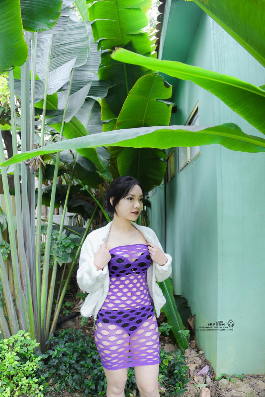 20P Brünettes asiatisches Mädchen posiert in sexy lila durchsichtigem Kleid im Freien